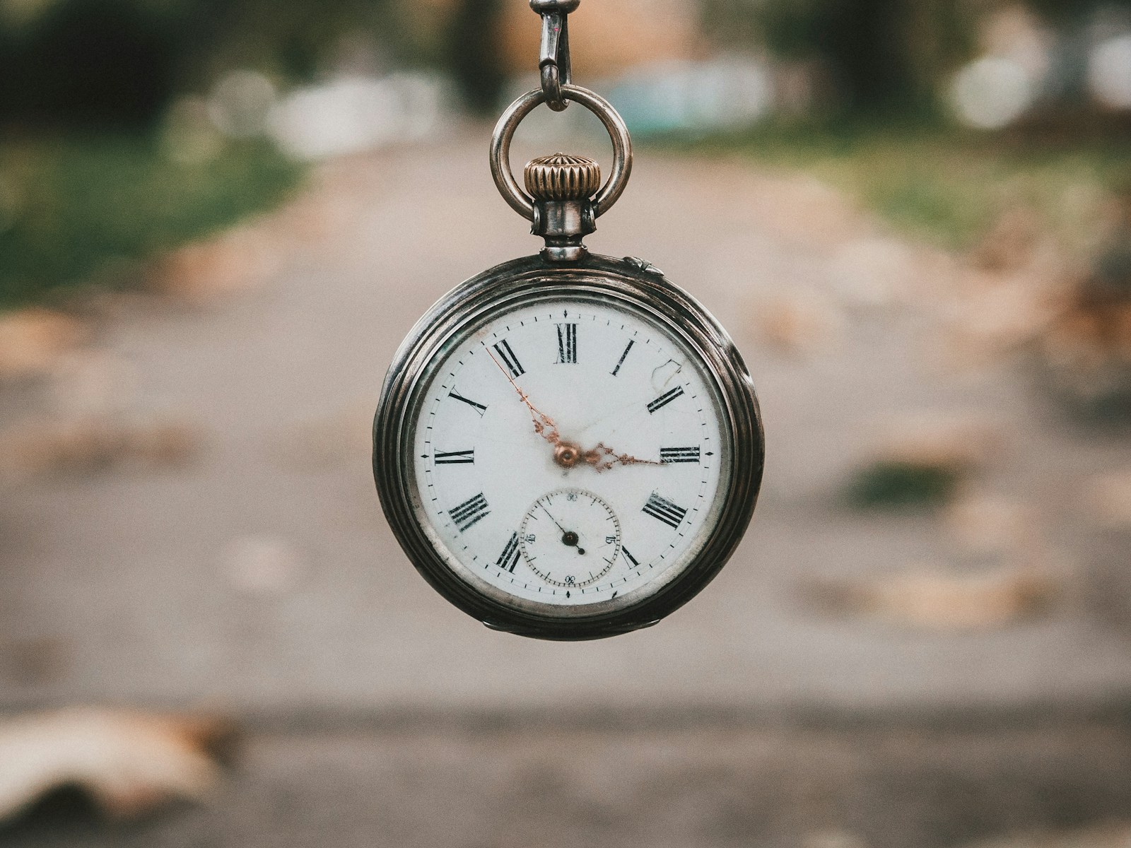 A vintage pocket watch resting on its open leather case.