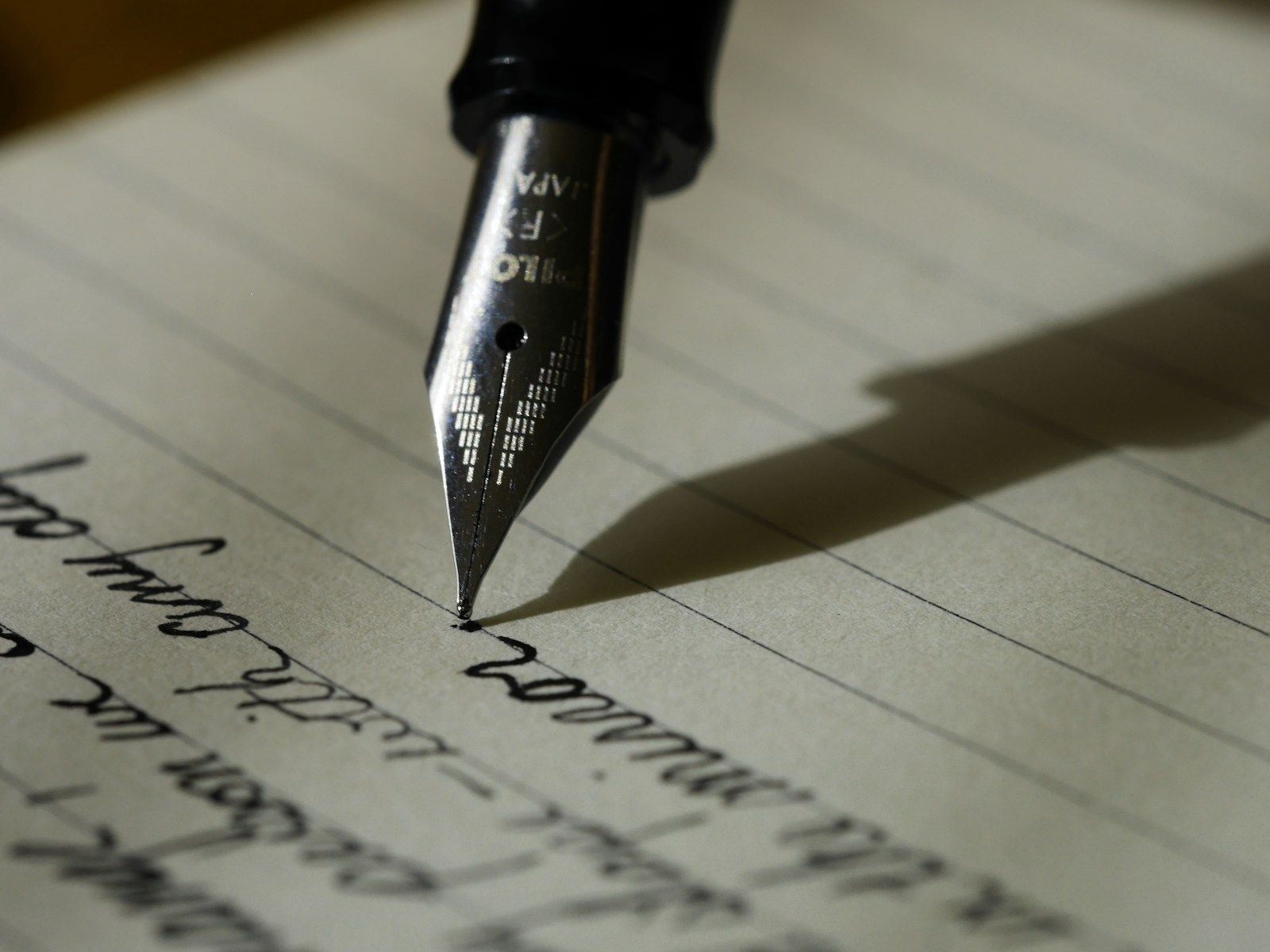 A leather notebook open beside an espresso cup on a dark wood table.